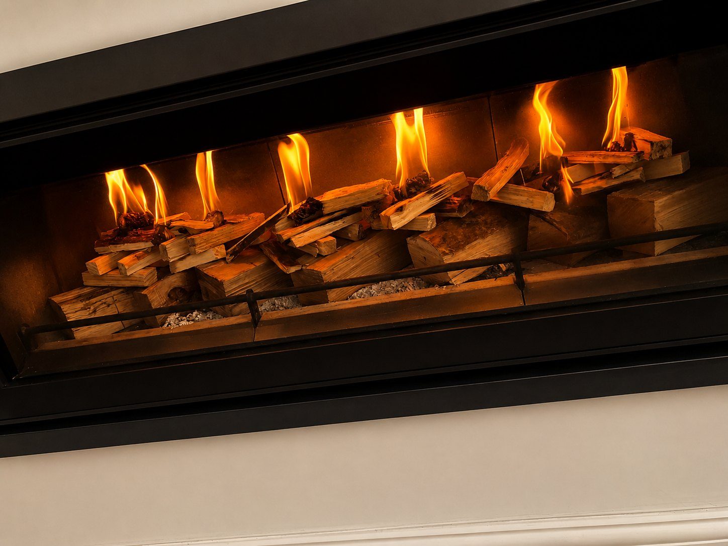 A warm, lit fireplace beside a comfortable armchair
