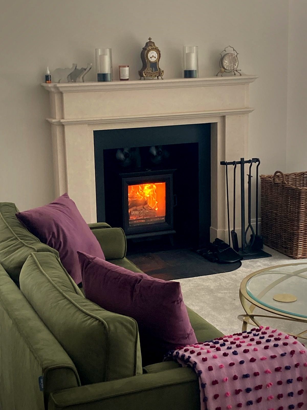 A solid-fuel stove set in a classic surround in a styled living room