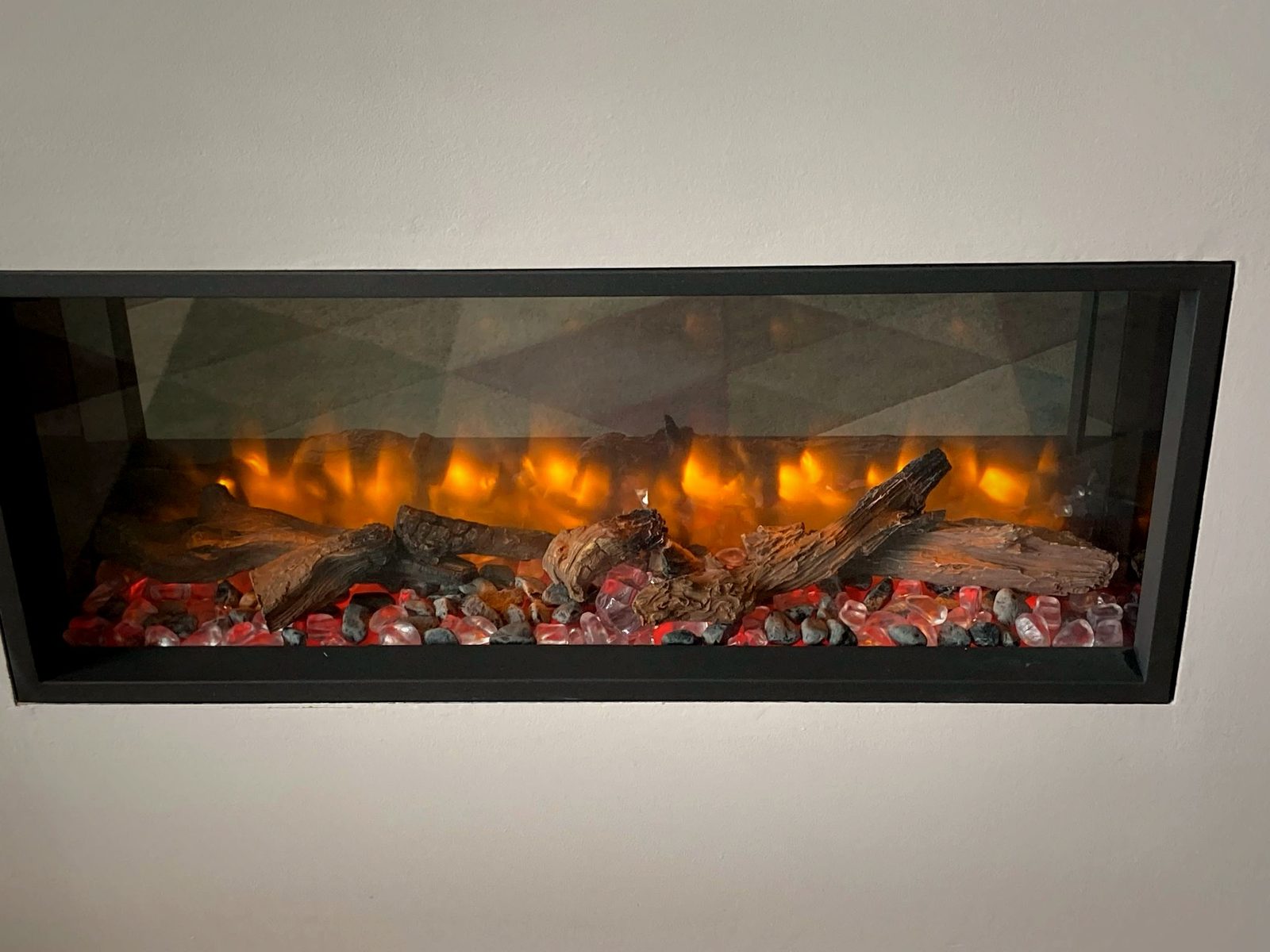 A long linear living-flame fire mounted in a feature wall